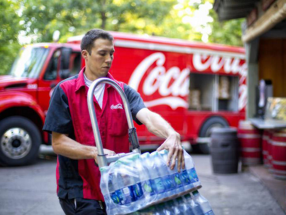 Un trabajador descargando agua embotellada del camión