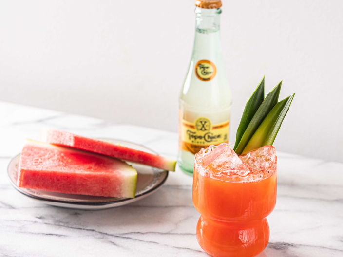 spicy punch drink next to watermelon and topo chico bottle