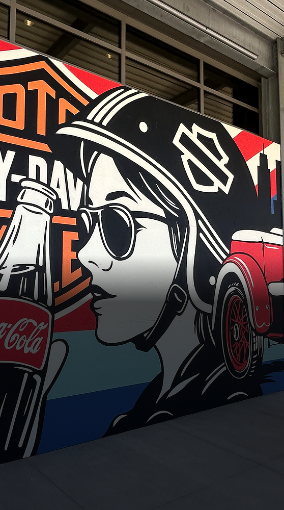 A pop-art mural in Milwaukee celebrating the partnership between Coca-Cola and Harley-Davidson with a woman holding a Coke bottle.
