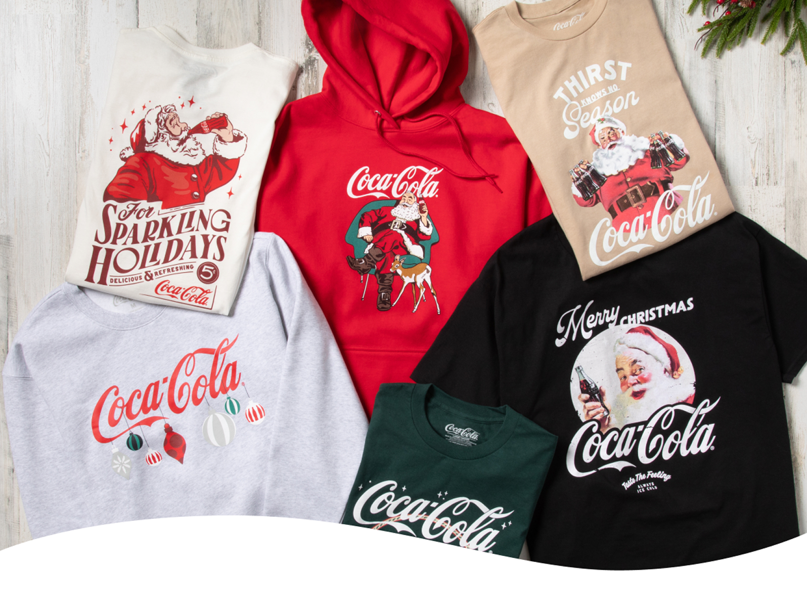 Coca-Cola branded T-shirts and sweatshirts featuring Santa imagery