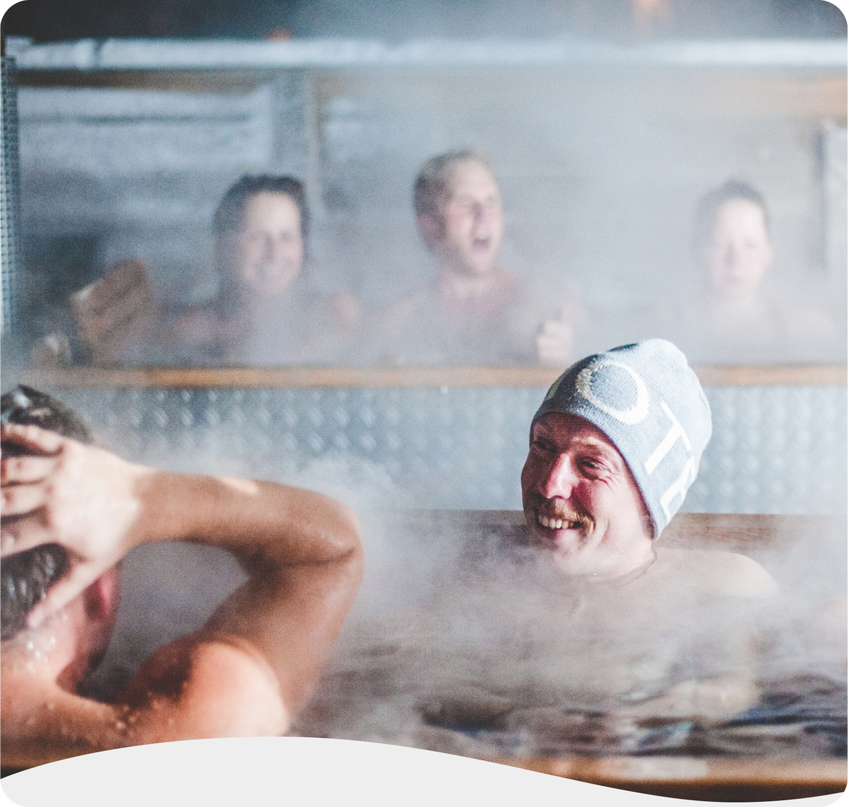 A group of men enjoying conversation in a steaming outdoor spa tub