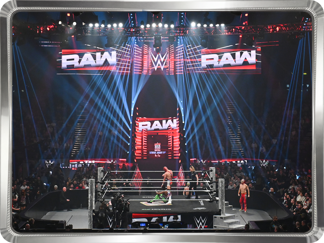 Wide shot of WWE Monday Night Raw ring and stage inside packed arena, used as promotional tile for Minute Maid x WWE partnership.