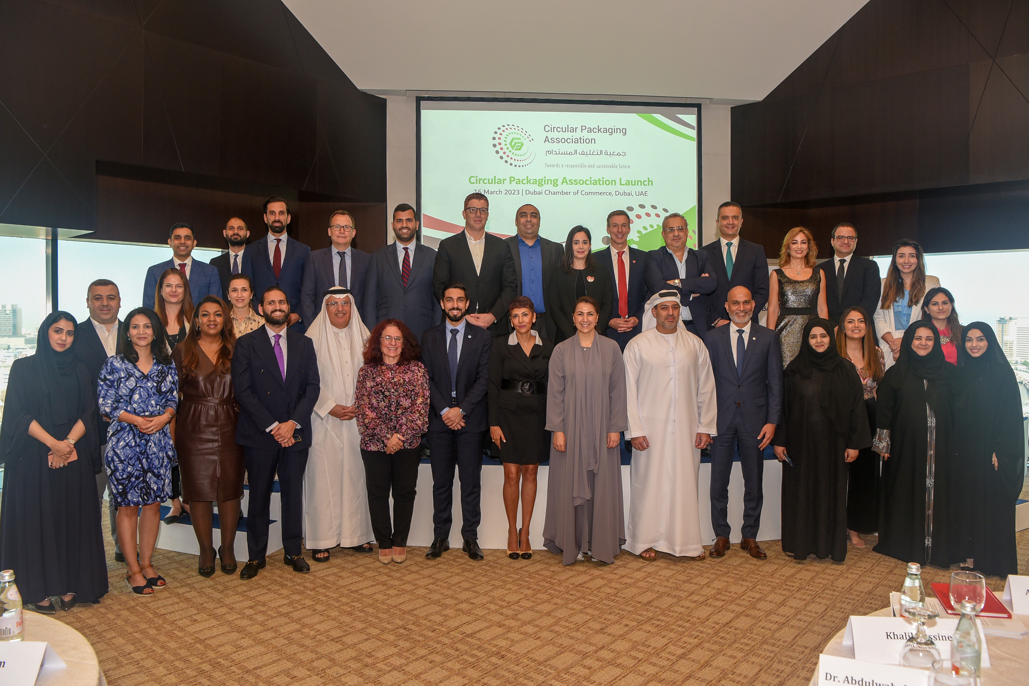 A group of individuals posing in front of a small stage at the Circular Packaging Association Launch